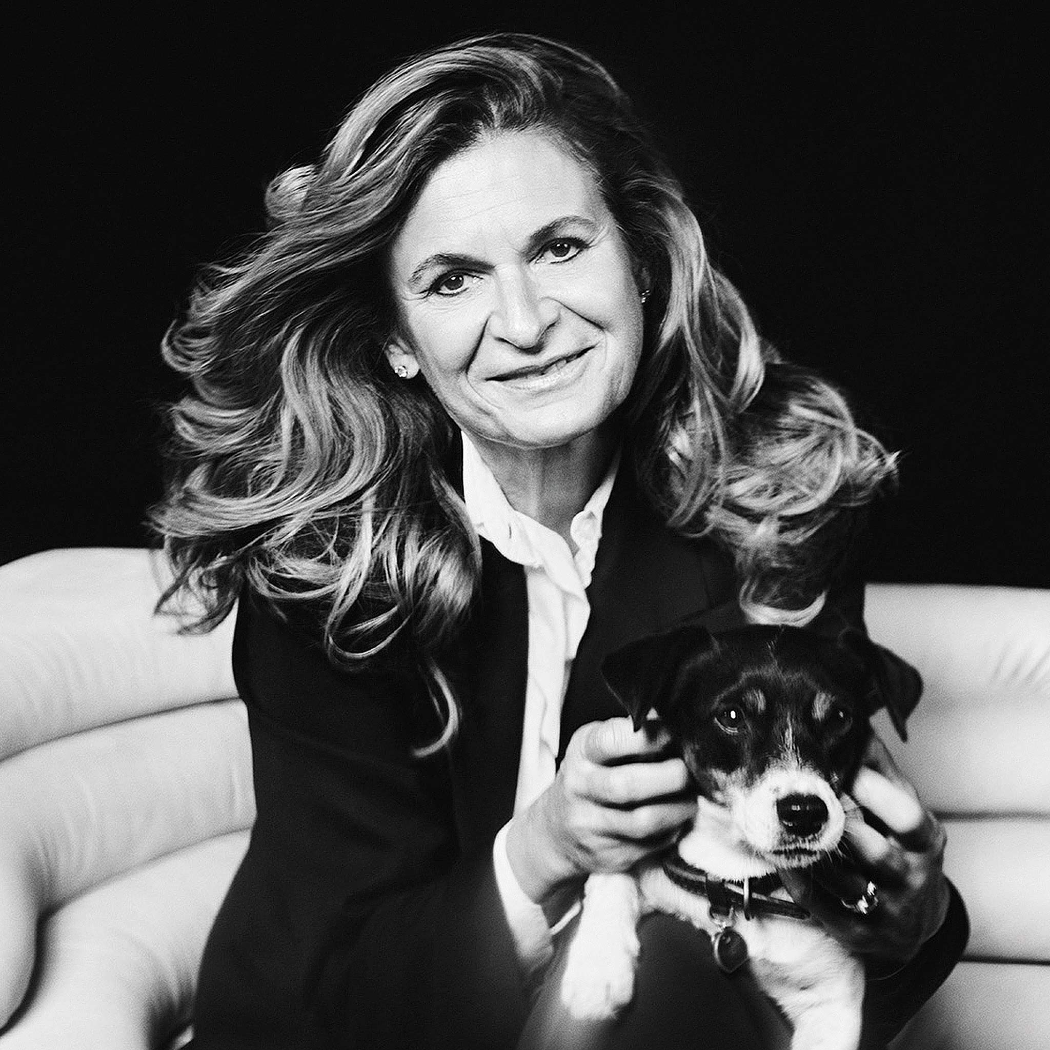 Es tut mir leid, ich kann nicht erkennen, wer auf dem Bild ist. 

Das Bild zeigt eine Frau mit einem Hund auf einem eleganten Lederstuhl von Frank Sitzmöbel Fsm.